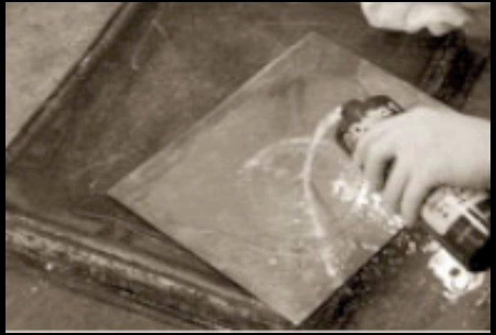 Hand working on a copper plate